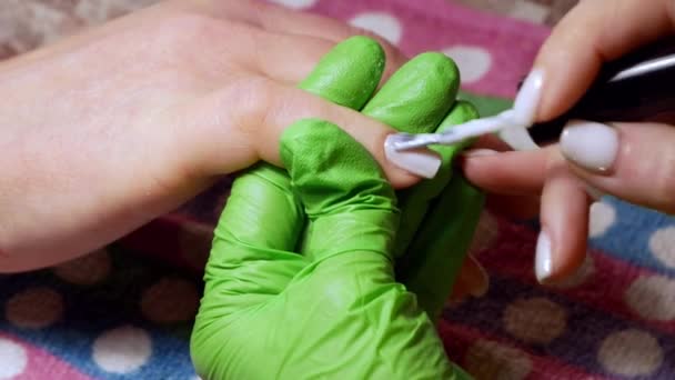 Manicure service. The manicurist paints her nails with white gel polish. Applying nail polish. Manicured white nails. A manicure master paints the clients nails in a beauty salon — Stock Video
