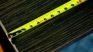 Yatay olarak yerleştirilmiş sarı metal ölçüm bandının yakın çekimi