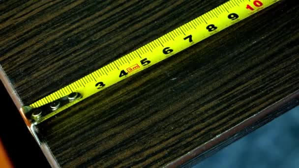 Primer plano de una cinta métrica de metal amarillo colocada horizontalmente — Vídeos de Stock