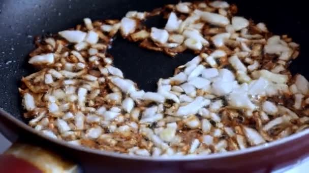 프라이팬에서 야채를 요리하기 위해 기름에 양파를 튀기라 — 비디오