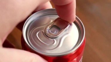 Ferahlatıcı kutu açılıyor, kapatın. Yetişkin adam elinde tutar soğuk alüminyum içeceği parmaklarıyla açar..