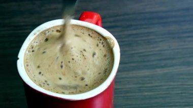 Bir fincan aromatik kahveye şeker karıştırır. Erkek eli kaşıkla kahve içmeyi karıştırır.