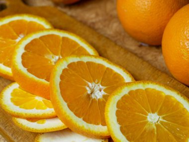 Taze portakal meyvesi ve bir tahtada dilimlenmiş.