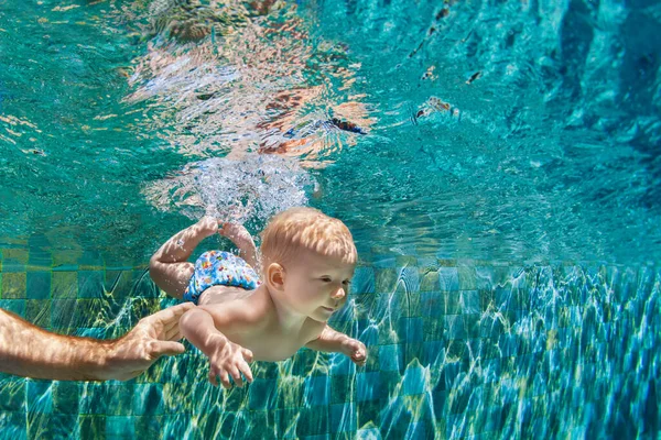幸せな人々が楽しく水中でダイビングします 父親の面白い写真 アクアパークスイミングプールの子供 家族のライフスタイル 子供たちのウォータースポーツ活動 夏休みに両親との水泳レッスン — ストック写真