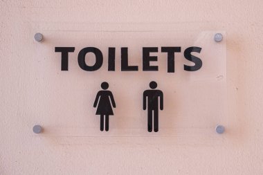 Yazı tuvaletlerinin olduğu cam tabela. Erkekler ve kadınlar için tuvalet bölmeleri için işaret. Bir otelde umumi tuvalet tabelası