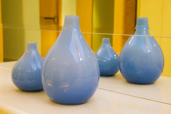 İki mavi seramik vazo aynaya yansıyor. Oda dekorasyonu için boş vazolar. Binanın minimalist tasarımı. Modern iç mekan detayları. Süslü oda dekorasyonu.