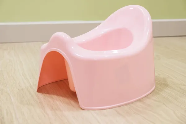 粉红塑料婴儿便盆在公寓的地板上 幼儿厕所训练室壶 — 图库照片