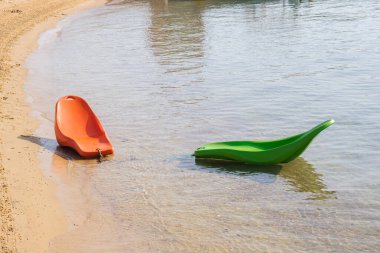 Su güneşliğinde yüzen plastikler. Plaj malzemeleri. Sahilin sığ kısımlarında güneşlenmek için uygun yerler..
