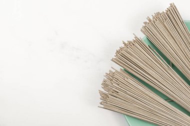 Hafif mermer bir tepside kuru soba karabuğday eriştesi. Geleneksel Japon yemekleri, Asya yemekleri ve sağlıklı yiyecekler hakkında pankart. Metin eklemek için aşçılık şablonu.