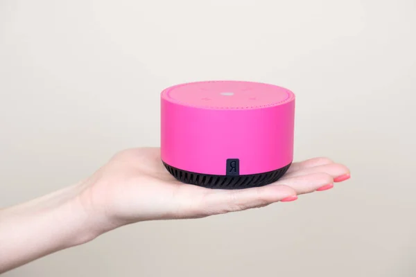 Kadın eli palmiye fuşya, akıllı hoparlör kolu Yandex istasyonunda. Mini Taşınabilir Bluetooth kablosuz ses hoparlörü asistanı. Moskova, Rusya - 11.24.2021