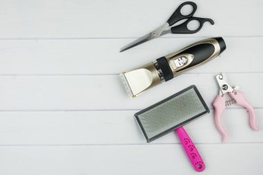 Set of tools for grooming: electric pet clipper, grooming scissors, wool brush and grooming scissors. Background with copy space on topic of pet care, Grooming, hygienic of cats and dogs. Top view clipart