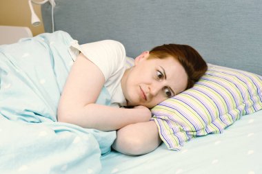 Kadın uyumaya çalışıyor ama baş ağrısı, stres ve depresyon yüzünden uyuyamıyor. Kadın hüzünlü düşüncelerle boğuşuyor. Çok çalıştığında uyku problemleri.