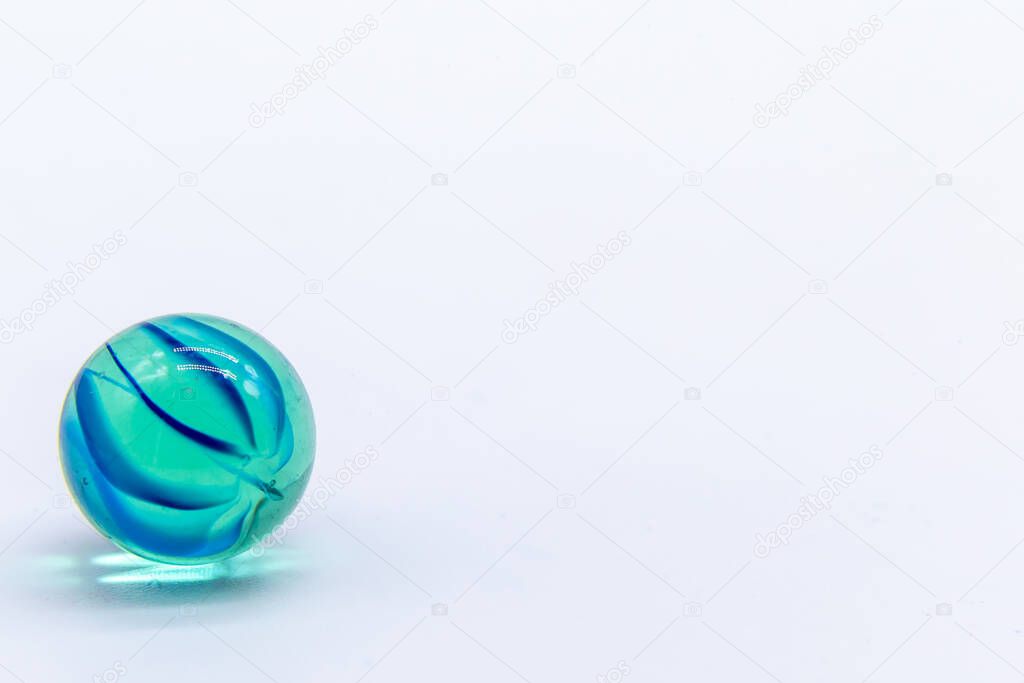One marble on white background. Colored glass ball