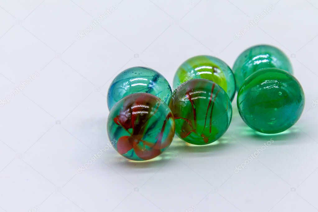 Six colored marbles placed two by two on a white background. Mac
