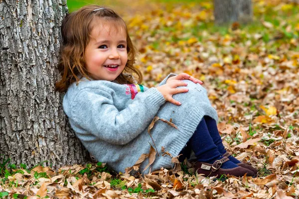 Liten Flicka Som Sitter Skogsgolvet Lutande Sig Mot Ett Träd — Stockfoto