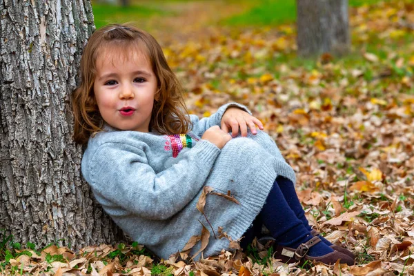 Liten Flicka Som Sitter Skogsgolvet Lutande Sig Mot Ett Träd — Stockfoto