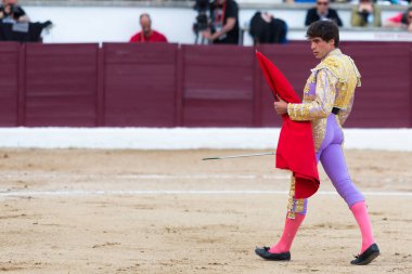 Madrid, İspanya... 30 Nisan 2022, San Martin de Valdeiglesias 'ta boğa güreşi. Koltuk değneği olan boğa güreşçisi. Boğa güreşi. Boğa güreşçisi ringde boğaya pas veriyor..