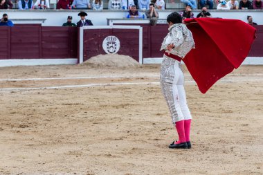 Madrid, İspanya... 30 Nisan 2022, San Martin de Valdeiglesias 'ta boğa güreşi. Koltuk değneği olan boğa güreşçisi. Boğa güreşi. Boğa güreşçisi ringde boğaya pas veriyor..
