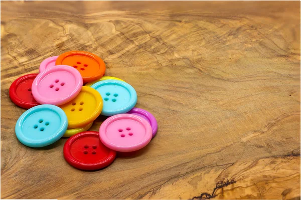 Colored buttons for clothes on a wooden table. Material for sewing. haute couture