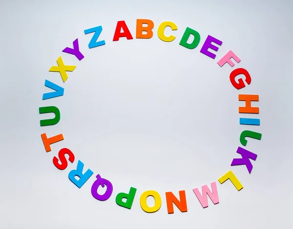 Letters of the alphabet form a circle on a white background. Alphabet of the Spanish language. Colored letters forming a circle.