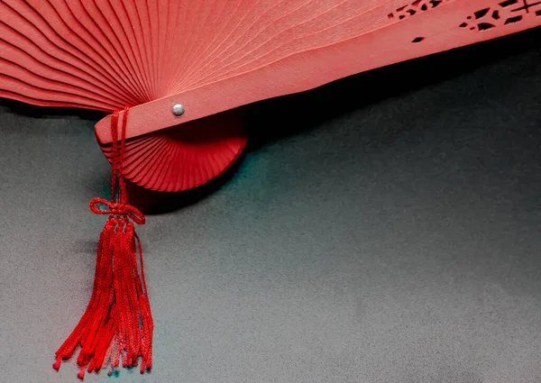 Red fan with details in the wood and thread tassel attached to the handle. Andalusian fan. Spanish costume accessory. Color fans.