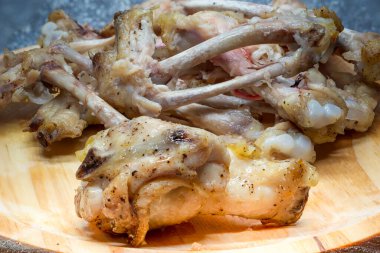 Leftovers. Chicken wing bones on a wooden board. Healthy food. Fried chicken meat. Chicken snacks.