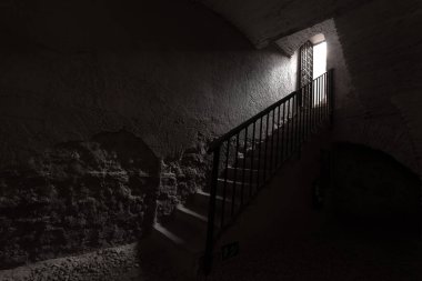 Işığın girdiği kapıya giden merdivenler. Gizemli oda. Siyah beyaz fotoğraf. Gizem ve korku sahnesi. Karanlıktan aydınlığa.