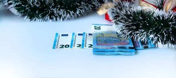 Yeni yıl hediyesi olarak para ve beyaz bir arka planda Noel. İzole edilmiş bir resim.