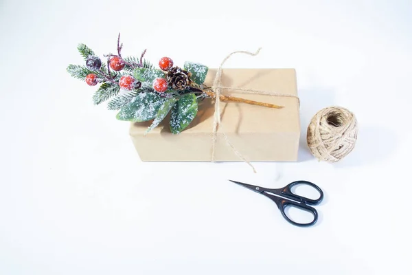 Il regalo è avvolto in carta artigianale con un ramoscello invernale — Foto Stock