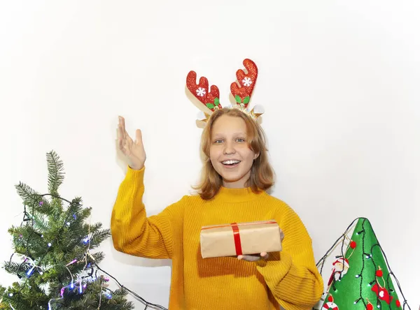 Sürpriz tatlı kız bir Noel hediyesi açtı. Odadaki süslü bir Noel ağacının yanında küçük bir çocuk bir kutu açtı..