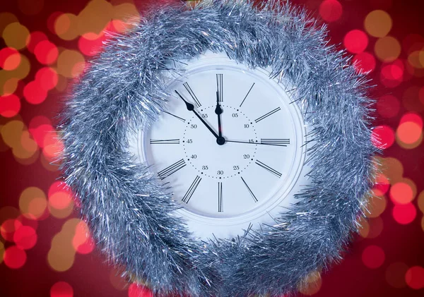 Новогодние часы на красном фоне — стоковое фото