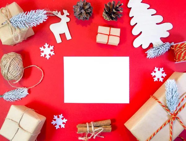 Noel hediyelerinin üstüne koniler, iplikler, geyikler, kar taneleri ve Noel ağacı. Mok up, kartpostal yazmak için, metin