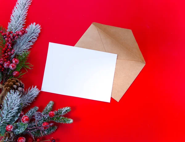 Weihnachtsbrief auf rotem Hintergrund mit Fichtenzweigen, Weihnachtsbaumspielzeug, Bastelgeschenk, Schneeflocken — Stockfoto