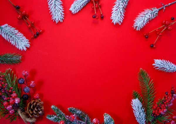 Carta de Natal em um fundo vermelho com ramos de abeto, brinquedos de árvore de Natal, presente de artesanato, flocos de neve — Fotografia de Stock
