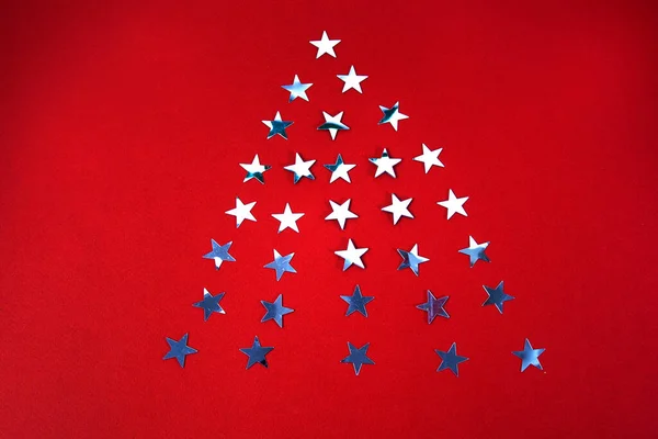 Рождественские звезды в виде рождественской елки на красном фоне — стоковое фото