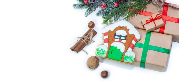 Weihnachtlicher Hintergrund mit Geschenken und Hausgebäck. Nüsse mit Vanille und Zimt, ein Zweig im Hintergrund. — Stockfoto