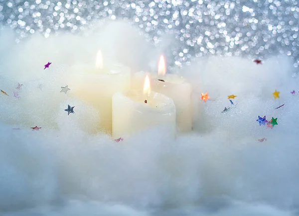 Рождественские горящие свечи на пушистом белом снегу на блестящем фоне. Свечи, свечи с рождественским декором. — стоковое фото