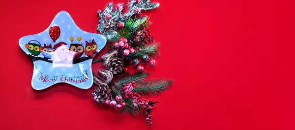 Kırmızı arka planda ladin dalları. Yeni yıl afişi. Noel arkaplanı.