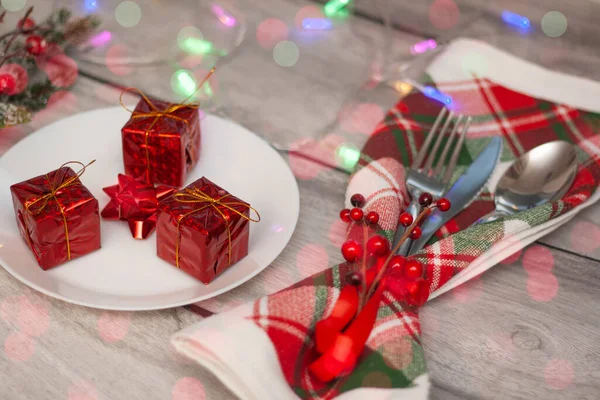 Widelec i łyżka i nóż na świątecznym drewnianym stole z prezentem. — Zdjęcie stockowe