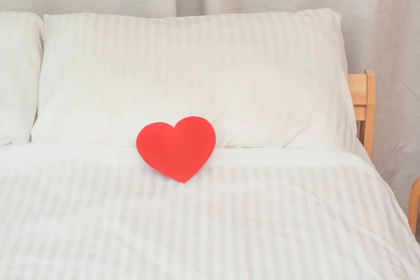 Beyaz yastıktaki kağıt kırmızı kalpler. Yatak odasında sevdiklerimiz için bir sürpriz..