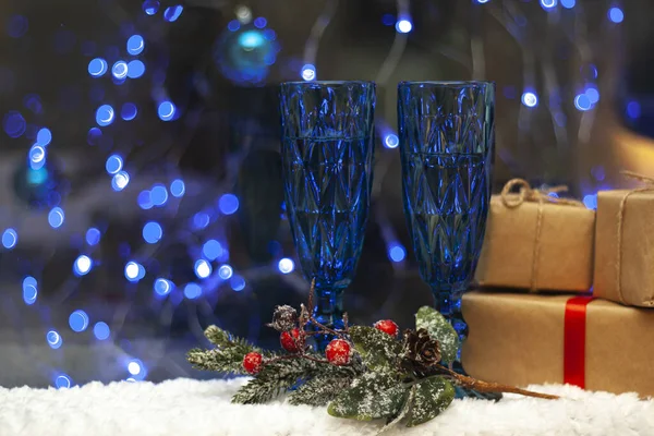 Blaue Brille auf dem verschwommenen Hintergrund des Weihnachtsbaums. Geschenke für Neujahr und Weihnachten. — Stockfoto