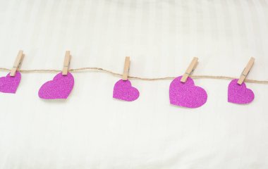 Beyaz yastıktaki kağıt kırmızı kalpler. Yatak odasında sevdiklerimiz için bir sürpriz..