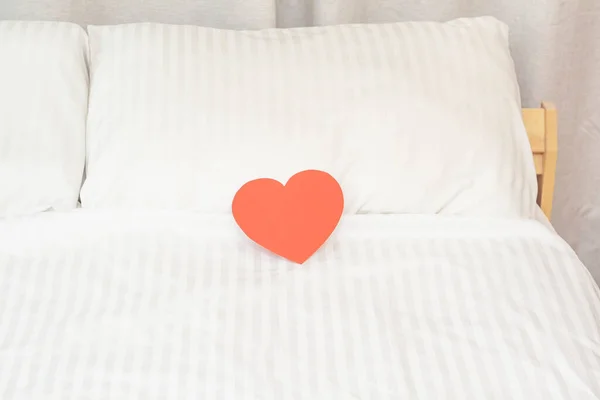 Beyaz yastıktaki kağıt kırmızı kalpler. Yatak odasında sevdiklerimiz için bir sürpriz..