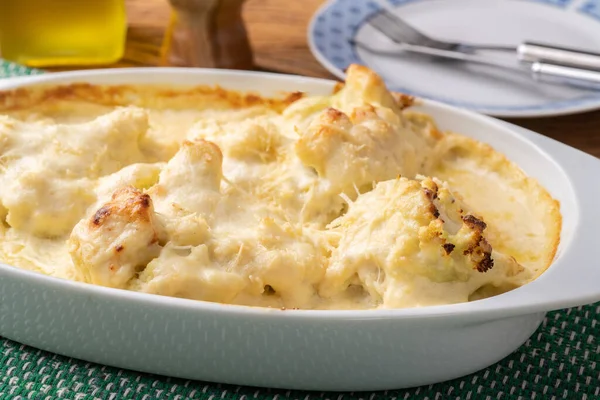 Beyaz tabakta parmesan peynirli Gratin karnabaharı..
