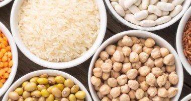 Beyaz kaseler üzerinde çeşitli fasulye ve tahıllar..