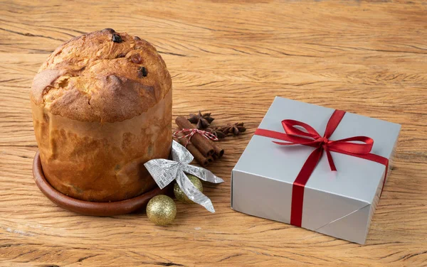 Traditional italian christmas fruit cake panettone with gift box and christmas decoration.