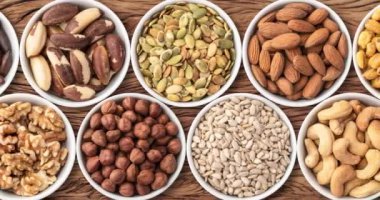 Tahta masa üzerinde fındık ve tohumlar, panoramik format.