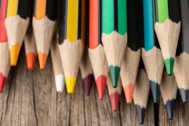 Dar odak, çeşitli renkli kalemler ahşap masanın üzerine yakın plan.