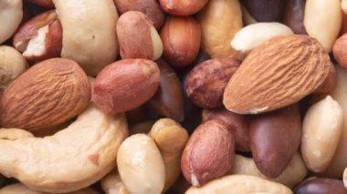 Ahşap bir arka planda karışık fındık manzarası. Fıstık, Brezilya fındığı, kaju, baru ve badem..