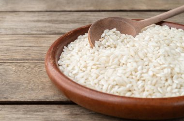 Dar odak, çiğ carnaroli risotto pilavı ahşap masa üzerinde fotokopi alanı ile birlikte..